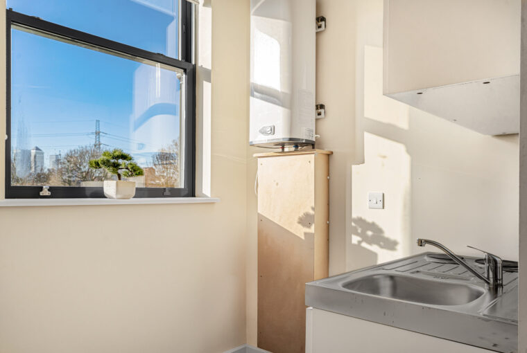 Sun shining through the large window onto the kitchenette