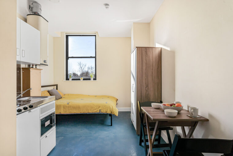 open planned living area with bed, dining and kitchen space