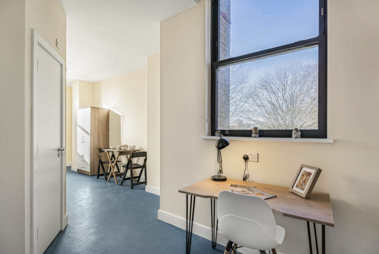 study area with desk leading to open planned living area
