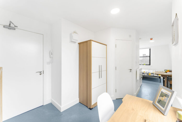 Interior view near the front door showing study area and wardrobe