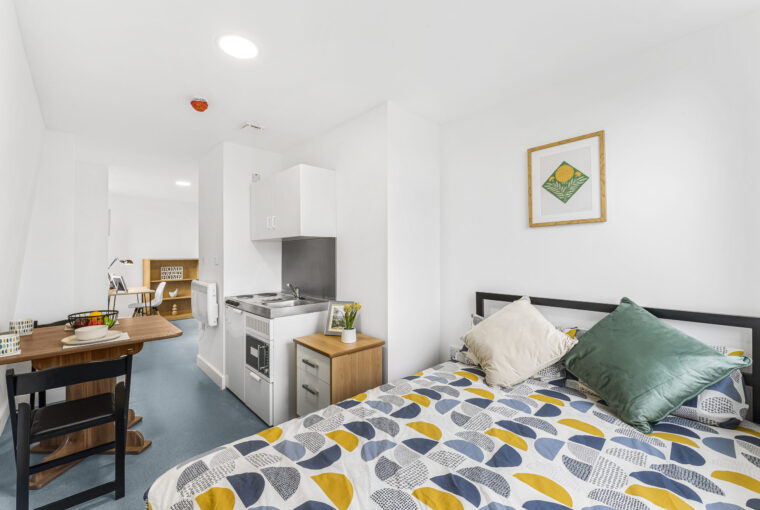 Interior view of the double bed, kitchenette and dining area