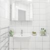 Upclose of sink in a white tiled bathroom with towel drying rack